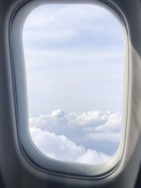 View of cloudy sky seen through airplane window