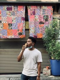 Full length of man standing against multi colored wall