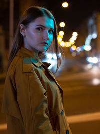 Portrait of young woman on road at night
