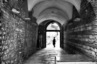 Rear view of woman walking in corridor of building