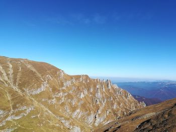 Scenic view of mountains against clear blue sky