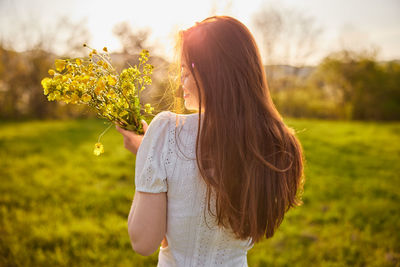 Rear view of woman standing against plants