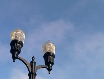 Low angle view of street light against blue sky