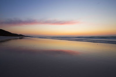 View of calm beach at sunset