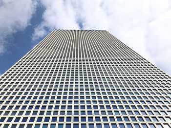 Low angle view of skyscraper against cloudy sky