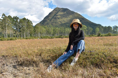 Portrait of beautiful woman on field against sky