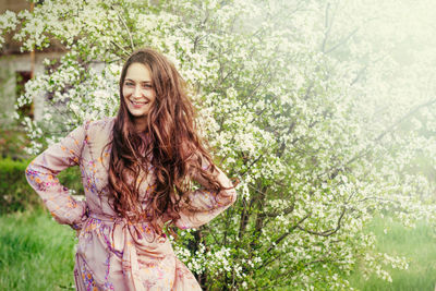 Portrait of a smiling young woman against plants