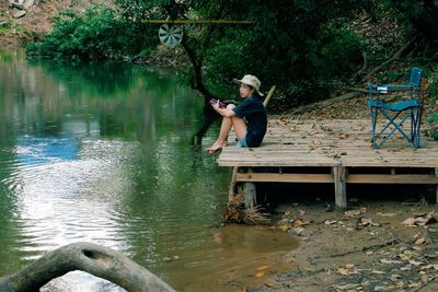 Full length of boy on lake against trees