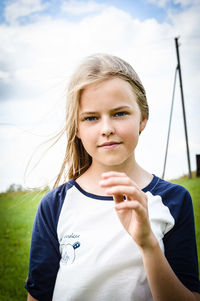 Portrait of teenage girl standing against sky