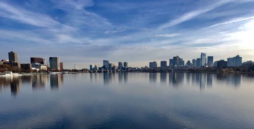 Scenic view of river by buildings against sky in city