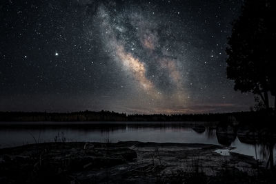 Scenic view of lake against sky at night