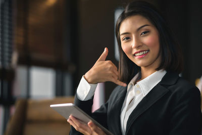 Portrait of a smiling young woman using smart phone