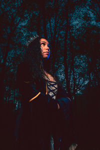 Young woman looking away in forest