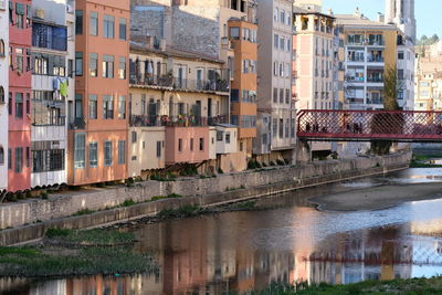 Bridge over river by buildings in city