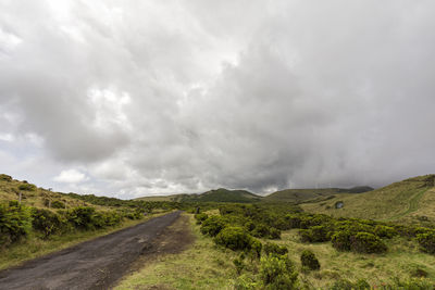 Road leading towards mountains against sky