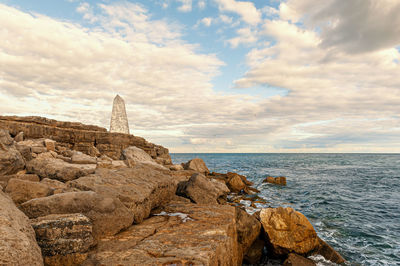 Rocks by sea against sky