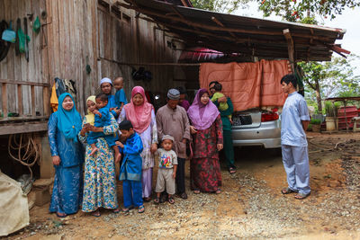 Rear view of people standing outside house