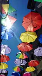 Low angle view of umbrellas hanging against sky