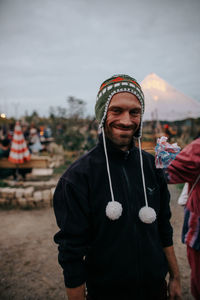 Portrait of smiling man wearing knit hat while standing on field