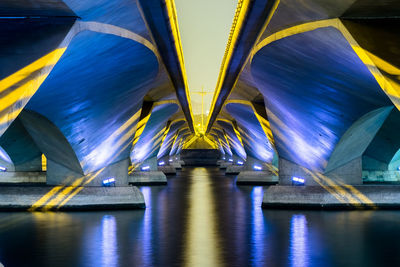 River below illuminated bridge at night