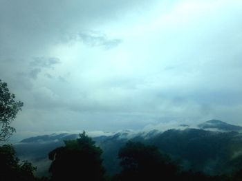 Scenic view of mountains against cloudy sky