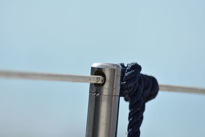 Low angle view of rope tied up against clear sky