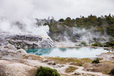 Scenic view of hot spring against cloudy sky