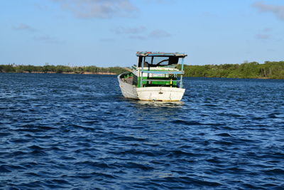 Boat sailing in sea against sky