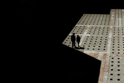 Silhouette people standing against wall