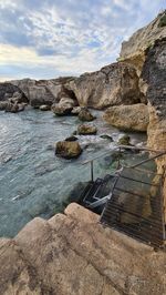 Rocks in sea against sky