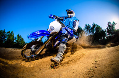 Man riding motorcycle against blue sky