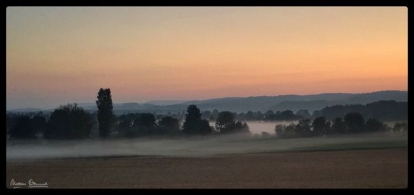 Scenic view of field against sky during sunset