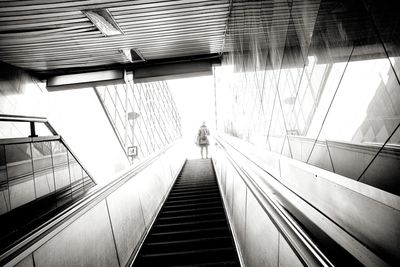 Rear view of woman on escalator