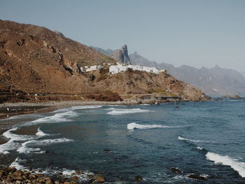 Scenic view of sea and mountains against clear sky