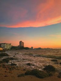 Scenic view of sea against dramatic sky during sunset