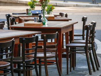 Empty chairs and tables at sidewalk cafe