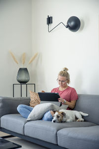 Woman on sofa using digital tablet