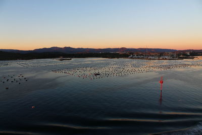 Scenic view of land against clear sky during sunset