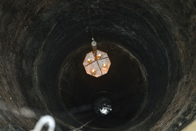 Close-up of illuminated lighting equipment dropping from well