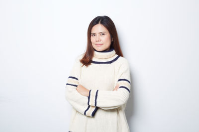 Portrait of a smiling young woman against white background