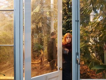 Portrait of young man looking through window