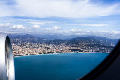Aerial view of sea and cityscape against sky