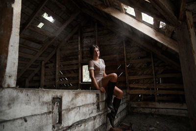 Woman sitting in abandoned building