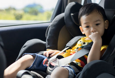 Cute boy sitting in car