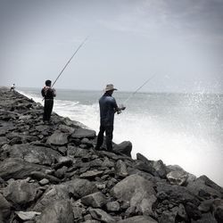 Rear view of man fishing in sea