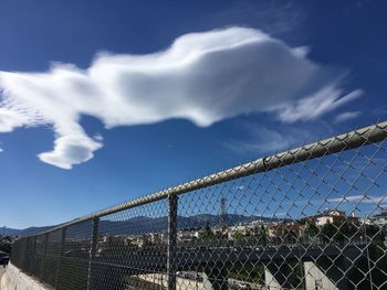 Low angle view of chainlink fence against sky