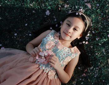 High angle view portrait of girl lying on field