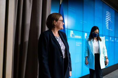 Woman standing against blue wall