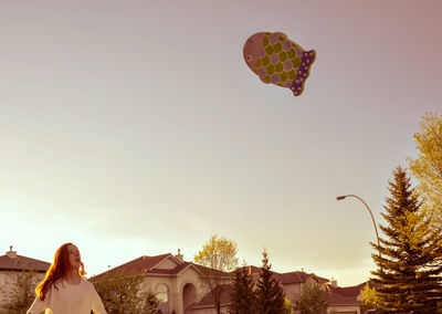 Low angle view of person paragliding against clear sky