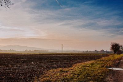 Scenic view of field against cloudy sky